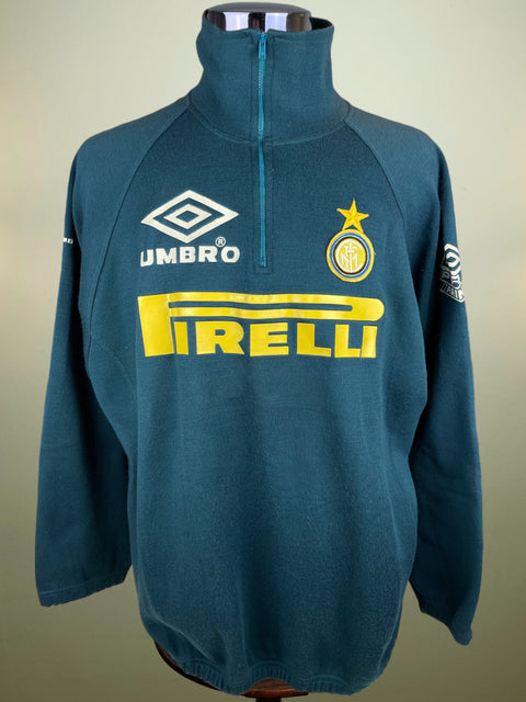 Teal Inter Milan sweatshirt with Umbro, Inter Milan, and Pirelli logos on a mannequin against a beige background