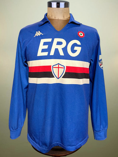Blue Sampdoria 1989-90 jersey with 'ERG' and other logos on a mannequin against a beige background