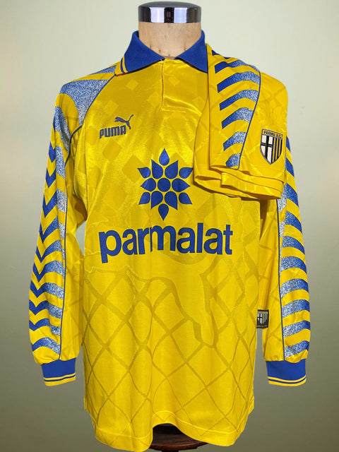 Yellow Parma 1995-97 jersey and shorts with blue accents on a mannequin against a neutral background