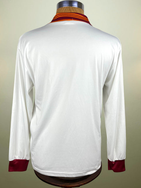 White long-sleeve AS Roma 1991-92 Away shirt with red cuffs and hem on a mannequin against a beige background