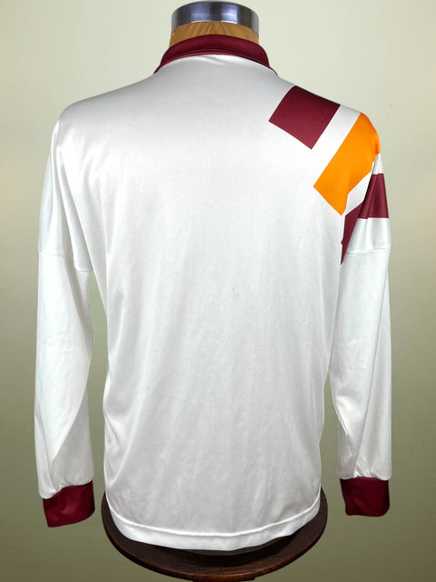 White AS Roma Football Shirt with red and orange accents on a mannequin against a beige background