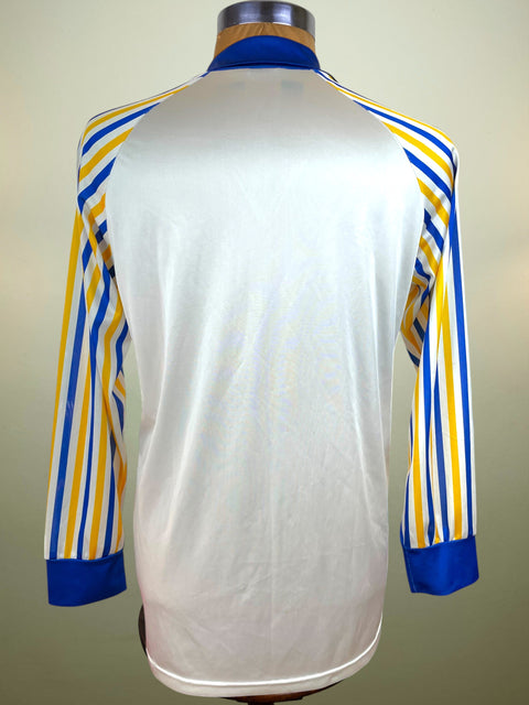 White Parma Calcio Umbro jersey with blue and yellow stripes on a mannequin against a beige background