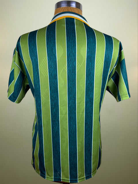 Green and blue striped Inter Milan Umbro 1995-96 Away jersey with Pirelli sponsor on a mannequin against a beige background