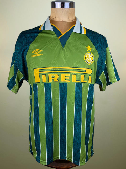 Green and blue striped Inter Milan Umbro 1995-96 Away jersey with Pirelli sponsor on a mannequin against a beige background