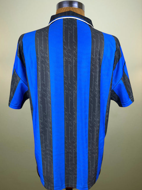Blue and black striped Inter Milan home shirt from the 1997-98 season on a mannequin against a beige background