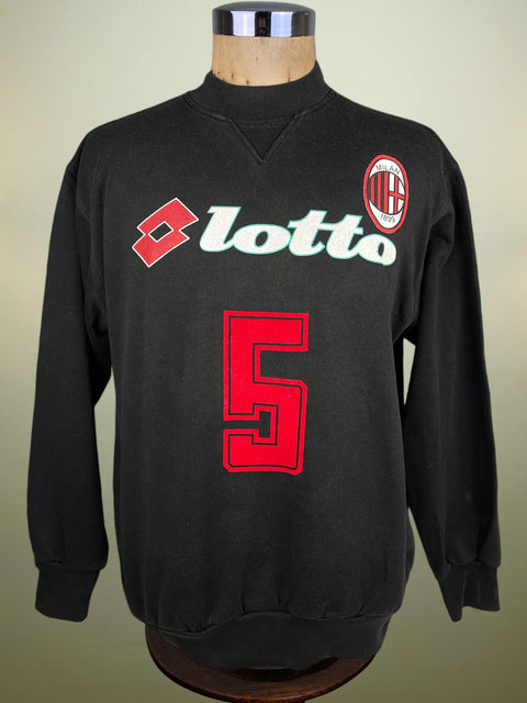 Black AC Milan sweater with Lotto and number 5 on a mannequin against a beige background