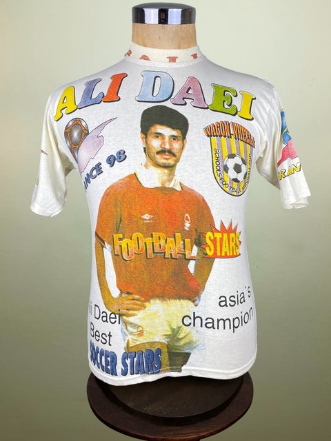 Soccer jersey with Ali Daei's image and text on a mannequin against a plain background
