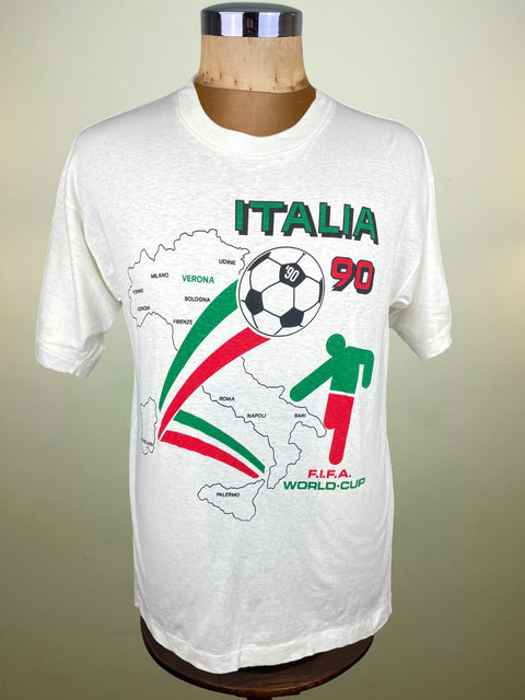 White t-shirt with 'Italia 90' design on a mannequin against a beige background