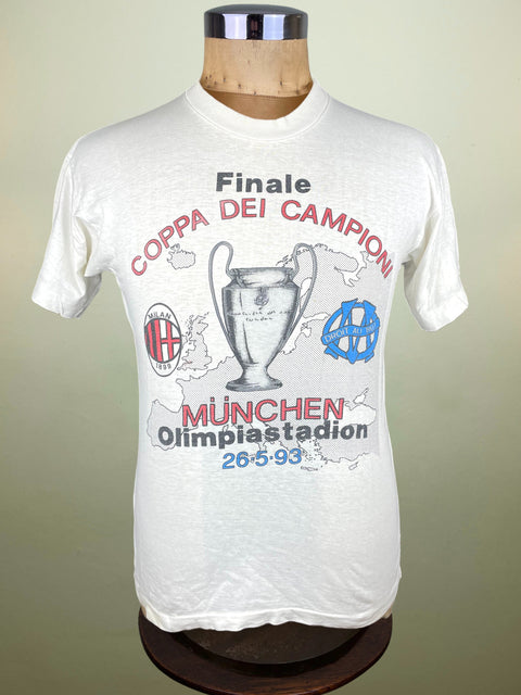 White t-shirt with Milan vs Marseille Champions League Final event graphics on a mannequin against a plain background.