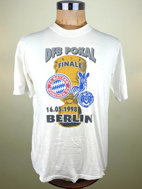 White t-shirt with sports event graphics on a mannequin against a neutral background