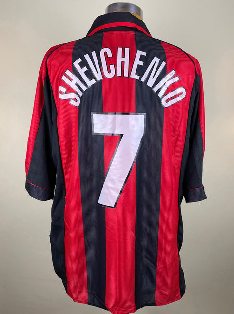A short-sleeved AC Milan jersey with red and black stripes, featuring the name 'SHEVCHENKO' and the number '7' on the back.
