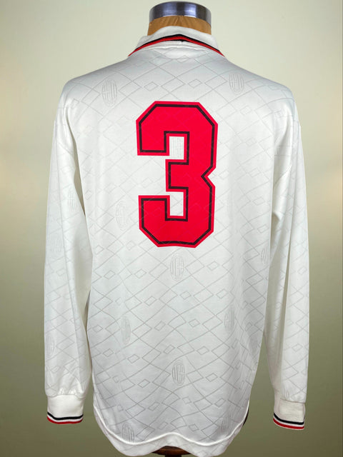 White AC Milan Lotto 1993-94 sports jersey with Paolo Maldini's red number 3 on a mannequin against a beige background