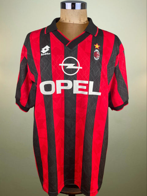 Red and black sports jersey with Opel logo on a mannequin against a neutral background