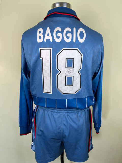 A blue soccer jersey with the name 'BAGGIO' and the number '18' on the back, along with the AC Milan club crest and a sponsor logo.