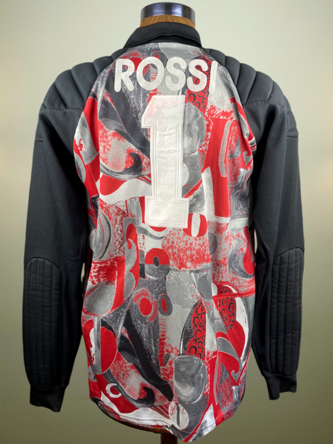 A long-sleeved AC Milan Goalkeeper jersey with a geometric pattern, predominantly red and black, with the name 'ROSSI' printed on the back.