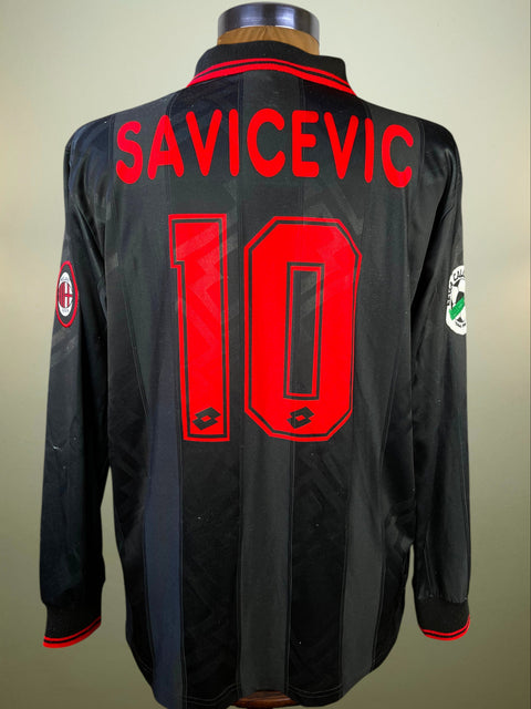 Black AC Milan 1996-97 Third Shirt made by Lotto with 'SAVICEVIC' and number '10' on a neutral background