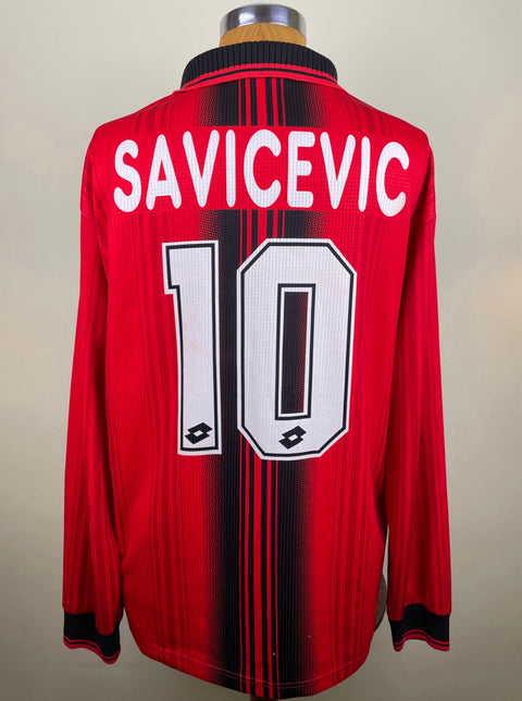 A red soccer jersey with long sleeves, featuring the name 'SAVICEVIC' and the number '10' on the back with the AC Milan club crest.