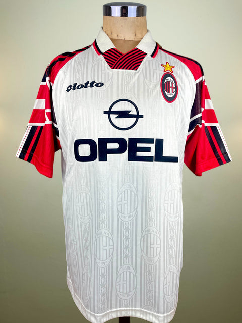 White AC Milan Pre-Season jersey with red and black accents and Opel Sponsor, made by Lotto on a mannequin against a plain background