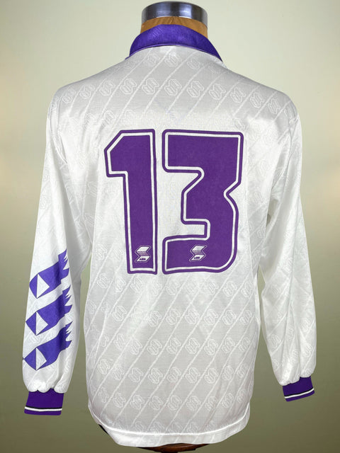 White Fiorentina jersey with purple number 13 in flock material and accents on a mannequin against a neutral background