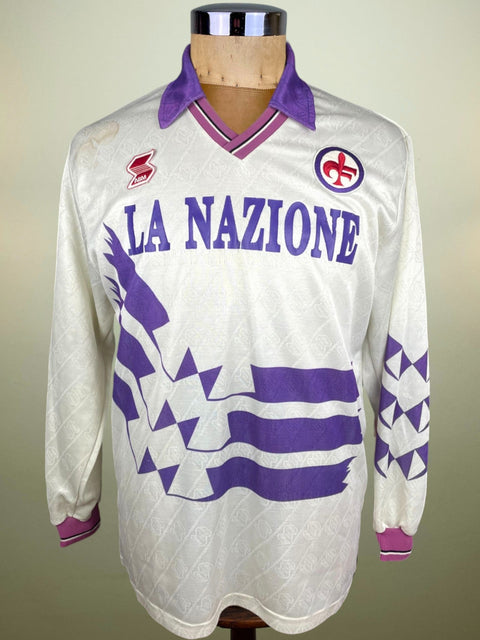 A long-sleeved 1990-91 Fiorentina jersey made by ABM featuring a geometric pattern with purple and gray stripes, and the text 'LA NAZIONE' on the chest.