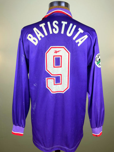 Match Worn Batistuta 1996-97 Home shirt in purple with Batistuta's name in white flock and his number 9 in the fabric of the shirt. On a mannequin against a plain background.