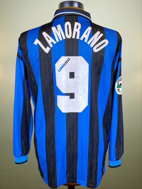 Blue and black striped Inter Milan jersey with 'ZAMORANO' and number '9' on a beige background