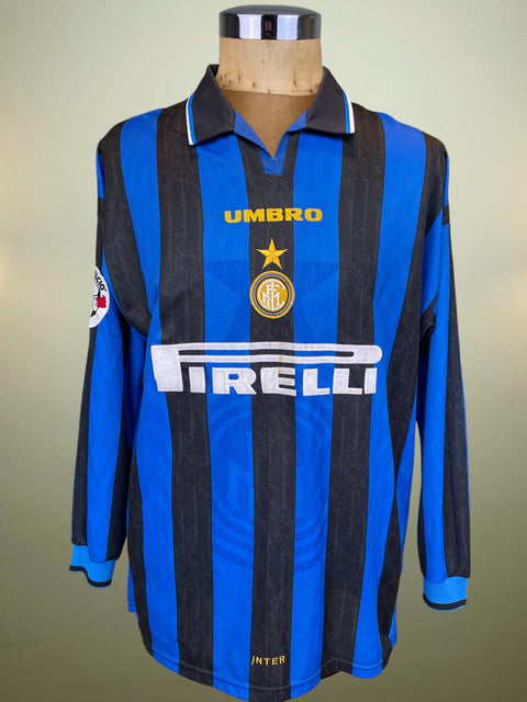 Blue and black striped sports jersey with Umbro and Pirelli logos on a mannequin against a neutral background.