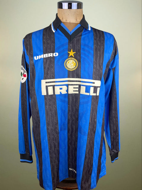 Diego Simeone's match worn long sleeved Inter Milan 1997-98 shirt with Blue and black stripes and Pirelli sponsor in light flock on the chest, against a plain background. This was worn against AC Milan as you can see from the error in the placement of the Inter logo on the chest.