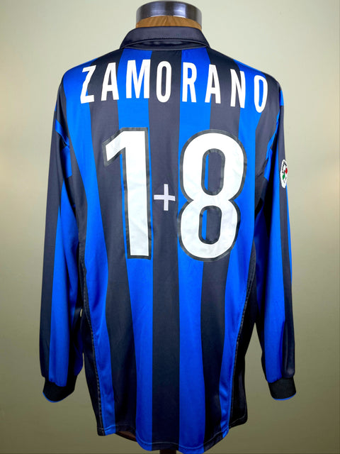 Blue and black striped Inter Milan 1998 home jersey with 'ZAMORANO' and number '18' on a beige background