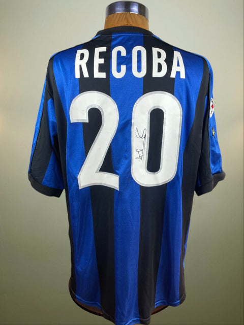 A Signed and match worn Alvaro Recoba Inter Milan 1999-00 home jersey with the name 'RECOBA' and the number '20' on the back, predominantly blue with black stripes, displayed on a mannequin.