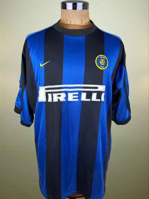 Blue and black striped Inter Milan jersey with Nike and Pirelli logos on a mannequin against a beige background