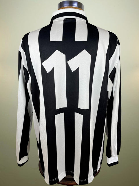 Black and white striped Fabrizio Ravanelli Juventus 1994-95 shirt with number 11 on a mannequin against a beige background