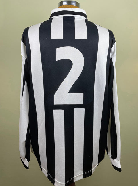 A black and white striped 1994-95 match worn Ciro Ferrara long sleeved jersey with number 2 printed into the fabric of the shirt, displayed on a mannequin.