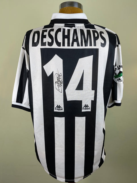 A short-sleeved match worn Juventus 1996-97 jersey with black and white stripes, the number 14, and the text 'DESCHAMPS' printed into the fabric of the shirt. The shirt is signed by Deschamps on the number.