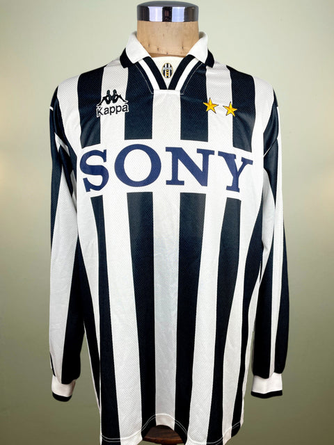 Black and white striped shirt with Kappa and Sony logos on a mannequin against a neutral background