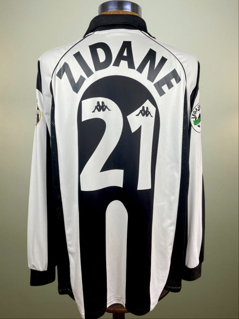 A match worn Zinedine Zidane Juventus 1997-98 home jersey with long sleeves, predominantly white with black stripes, displaying the name 'ZIDANE' and the number '21' printed on the back.