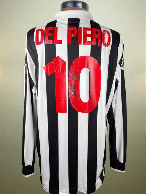 Black and white striped Juventus jersey with 'Del Piero' and number '10' on the back with his autograph in the '0' of the number on a mannequin against a beige background
