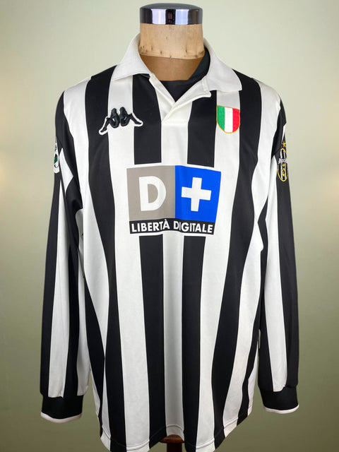 Black and white striped Juventus 1998-98 with a kappa logo and D+ Liberta DIgitale Sponsor on a mannequin against a neutral background