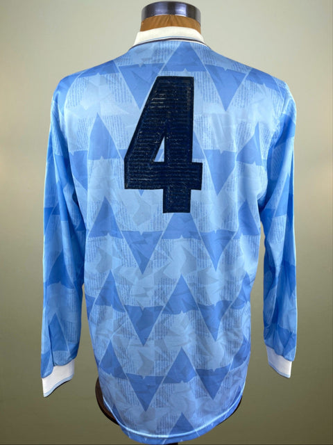 A blue long-sleeved match worn Lazio 1989 home soccer Jersey on a mannequin, featuring geometric patterns with the number 4 painted on the back.