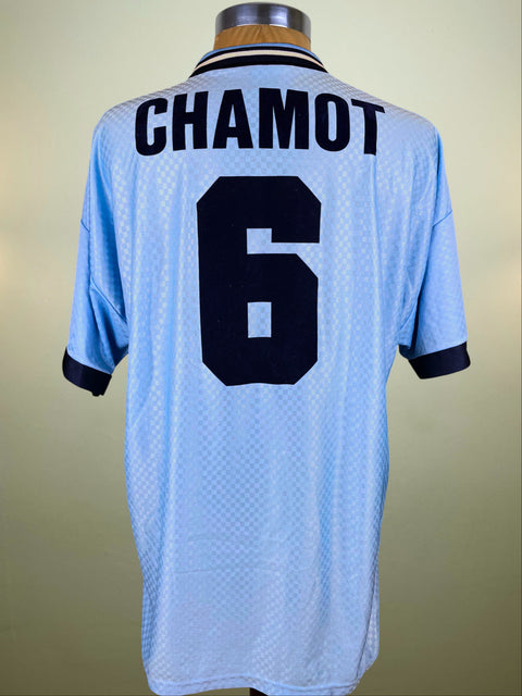 Light blue Lazio 1995 jersey with 'CHAMOT' and number '6' on a beige background