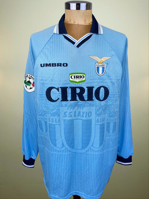 Light blue Lazio 1997 home jersey with Cirio branding on a mannequin against a beige background