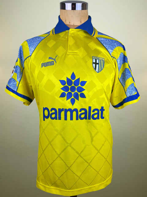 Yellow sports jersey with blue accents on a mannequin against a beige background