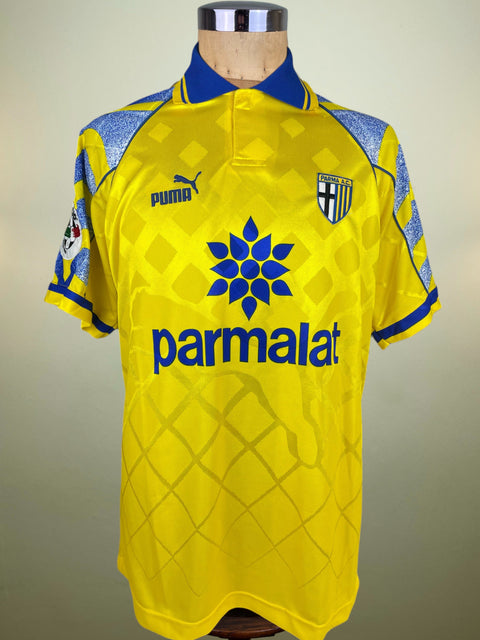 Yellow Match worn Parma 1996-97 jersey with blue accents on a mannequin against a neutral background and Serie A patch on the arm