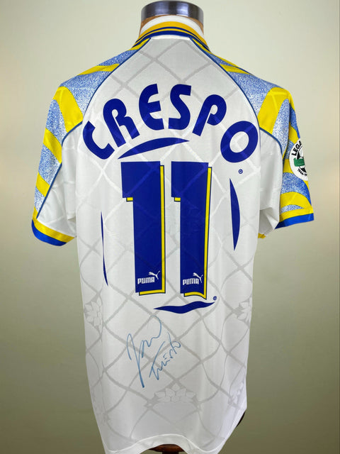 White Parma 1996-97 match worn jersey with blue and yellow accents, featuring the name 'Crespo' and number '11', with his signature in blue pen near the base of the shirt.