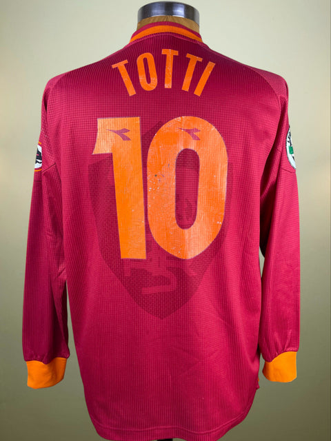 Red sports jersey with 'Totti' and number '10' on a mannequin against a beige background