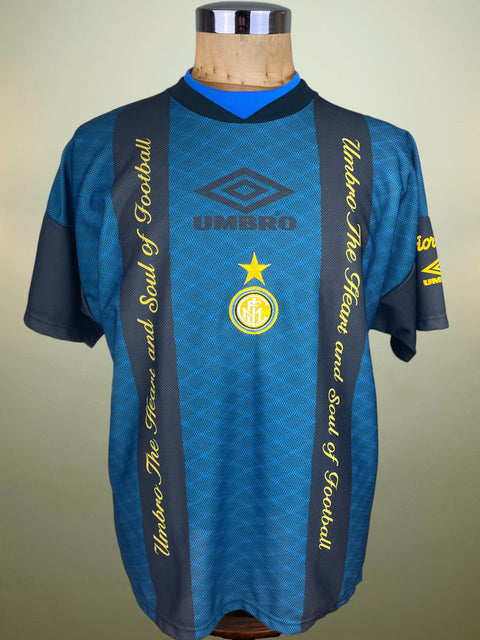 Blue Inter Milan Umbro Training jersey from the 1994-95 season with yellow text and Umbro logo on a mannequin against a beige background