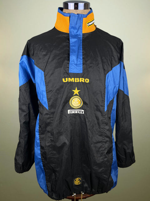 Black and blue Inter Milan Waterproof jacket with Umbro and Inter Milan logos on a mannequin against a beige background