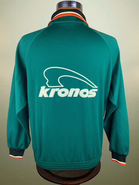 Green jacket with 'kronos' logo on a mannequin against a beige background