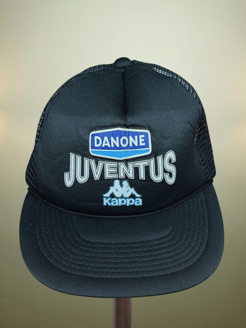 Black cap with Juventus and Danone branding on a beige background