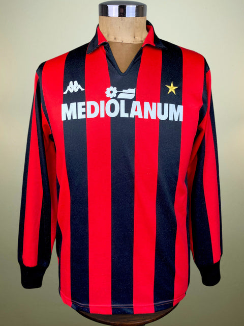 A vintage long-sleeve AC Milan jersey with red and navy blue vertical stripes, featuring the white Kappa logo, the Mediolanum sponsor text, and a gold star on the chest, displayed on a mannequin.